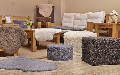 Showroom displaying curly sheepskin rugs and ottomans